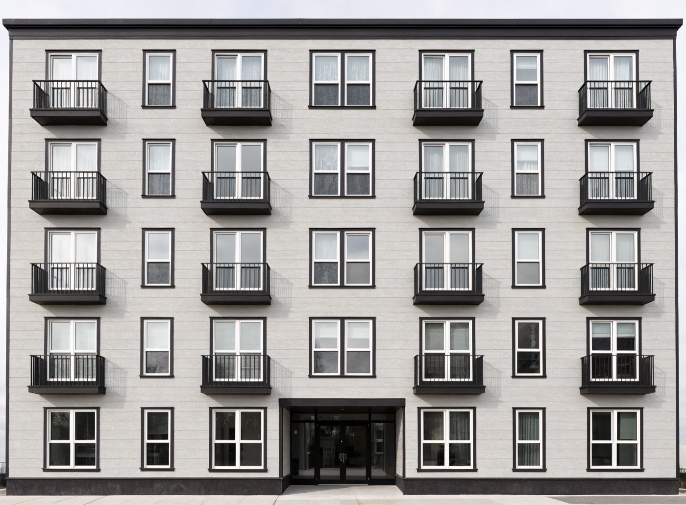 A four storey apartment building seen straight on.